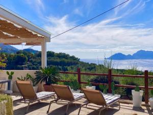 een patio met stoelen en uitzicht op de oceaan bij Villa Manu in Massa Lubrense