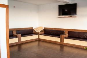 HOROKO HOTEL في نوسي بي: غرفة انتظار مع مقاعد بنية وتلفزيون بشاشة مسطحة