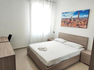 - une chambre dotée d'un lit avec des draps blancs dans l'établissement B&B Bologna, à Bologne