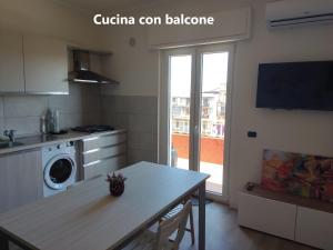 cocina con mesa y lavadora en Sunrise Apartment Marina Beach, en Marina di Gioiosa Ionica