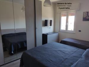 1 dormitorio con 2 camas y espejo en Sunrise Apartment Marina Beach, en Marina di Gioiosa Ionica