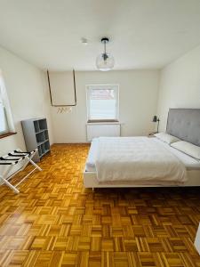 1 dormitorio con 1 cama y suelo de madera en A14 Three Bed Apartment City Center, en Heidenheim an der Brenz