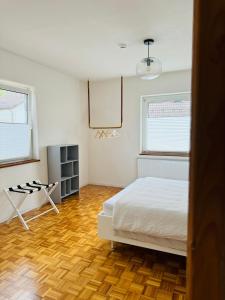 a bedroom with a white bed and two windows at A14 Three Bed Apartment City Center in Heidenheim an der Brenz