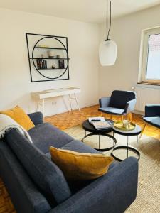 a living room with a blue couch and tables at A14 Three Bed Apartment City Center in Heidenheim an der Brenz