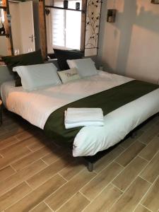 ein großes Bett mit zwei Handtüchern darüber in der Unterkunft Le Petit Paradis de Marcelise in Le Ponchel