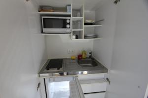 a small kitchen with a sink and a microwave at Kleine Wohnung für Singles in Daun