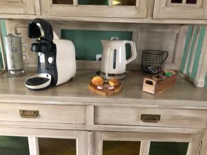 a kitchen counter with a coffee maker and a blender at Le Petit Paradis de Marcelise in Le Ponchel