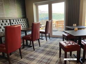 a dining room with tables and chairs and a patio at Foyers House in Foyers