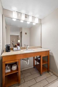 a bathroom with a sink and a large mirror at Travelodge by Wyndham Pueblo in Pueblo +21 photos