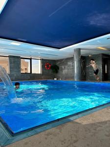 two people in a swimming pool with a blue ceiling at وحدات فندقية خاصة-crown suite in Al Jubail