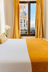 een slaapkamer met een bed en uitzicht op een gebouw bij Hostal Josefina-Gran Vía in Madrid