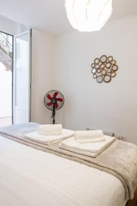Una cama con sábanas blancas y un ventilador. en Diogo's Alcântara Apartment II by Mycelia, en Lisboa
