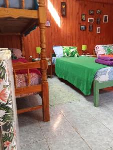 a bedroom with two beds and a green blanket at Eka Hotel in Nueva Palmira