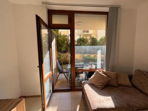 een woonkamer met een bank en een glazen schuifdeur bij Apartment Siana 3 in Sveti Vlas