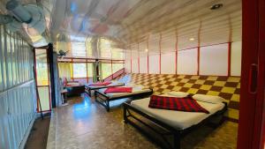a room with three beds in a room at Misty Green Coorg in Madikeri