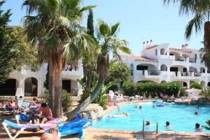 a group of people in the swimming pool at a resort at Apartamento en Cala en Porter Menorca in Cala'n Porter