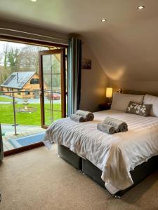 a bedroom with a large bed and a large window at Artro Lodge Luxury 3 Bedroom, 3 Bathroom & Hot Tub in Llanbedr +26 photos