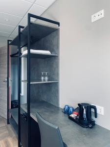 a black book shelf with a coffee maker on it at Vagnsstadir Guesthouse in Borgarhöfn