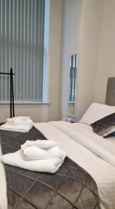 two white towels are sitting on two beds at Charming 1-Bed Apartment in Leeds in Leeds