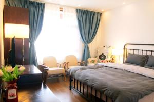 麗江的住宿－La Maison du Laoshay Lijiang，卧室配有一张床和一张桌子及椅子
