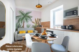 cocina y sala de estar con mesa y sillas. en ROMARIN * Lumineux * Linge hôtelier * Fibre * Confort, en La Destrousse