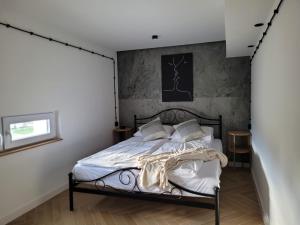 um quarto com uma cama preta com lençóis e almofadas brancos em AXO-HOSTELS em Stalowa Wola