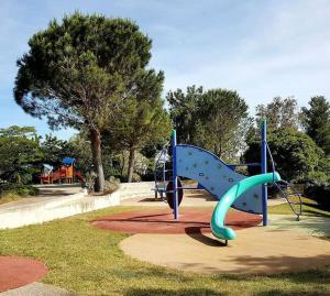 einen Spielplatz mit Rutsche in einem Park in der Unterkunft Le Petit Bonheur - Location de vacances (Studio 4P) in Roquebrune-sur-Argens