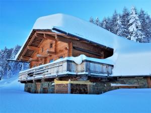 une cabane en rondins avec de la neige au-dessus dans l'établissement Ferienwohnung BodnLois, à Matrei in Osttirol