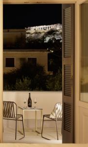un patio con tavolo, 2 sedie e finestra di La Divina ad Atene