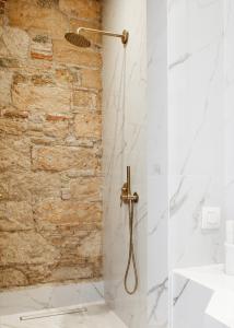a bathroom with a shower with a stone wall at La Divina in Athens