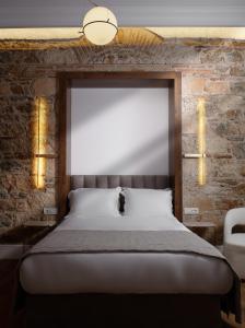 a bed in a room with a brick wall at La Divina in Athens +77 photos