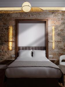 a bed in a room with a brick wall at La Divina in Athens