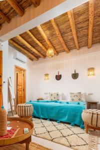 1 dormitorio con cama azul y techo de madera en Riad Mama, en Marrakech