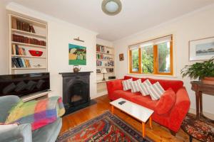 sala de estar con sofá rojo y chimenea en Serene 2BD Home wGarden Newtown Little Dublin! en Rathgar