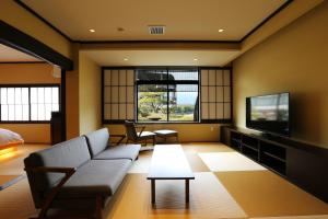 a living room with a couch and a tv at Taikyourou in Miyazu