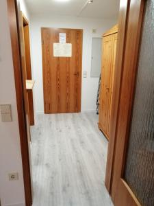 a hallway of an empty room with a wooden door at Frisch renovierte, familienfreundliche 1-Zi FeWo am Bach und zwischen zwei Seen 