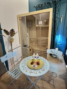 um quarto com uma mesa e cadeiras e um chuveiro em Suite bien être - jacuzzi et sauna / love room em Arpajon