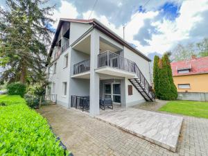 einen Außenblick auf ein weißes Gebäude mit einem Balkon in der Unterkunft MIHI APARTMAN in Balatonvilágos