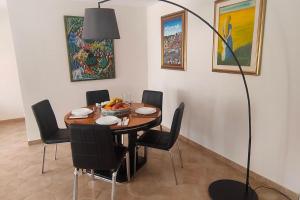 a dining room with a table and chairs and paintings at Appartamento con piscina per 4 persone in San Cataldo