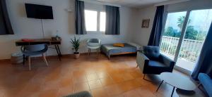 a living room with a couch and a table and chairs at Hostal Bahía Azul in Portocolom