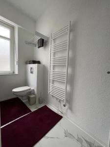 a white bathroom with a toilet and a window at NEU! Moderne FeWo Blumenhaus in Idar-Oberstein