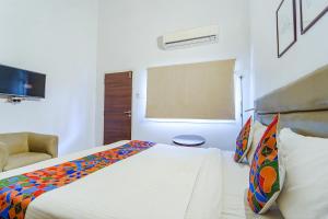 a bedroom with a large bed and a chair at FabExpress Le Aham Boutique in Pondicherry