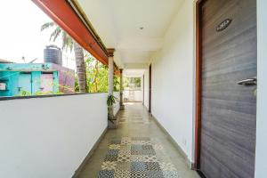 a hallway with a door and a tile floor at FabExpress Le Aham Boutique in Puducherry