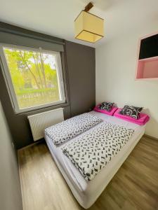 Dormitorio pequeño con cama y ventana en MIHI APARTMAN en Balatonvilágos