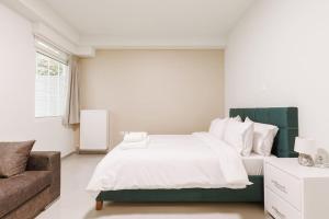 ein Schlafzimmer mit einem großen Bett und einem Sofa in der Unterkunft Snug studio apartment with pvt garden access I in Athen
