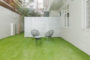 Snug studio apartment with pvt garden access I في أثينا: كرسيين وطاولة في غرفة مع عشب