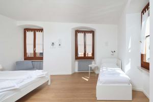 una camera con due letti e due finestre di Casa Morellato a Riva del Garda