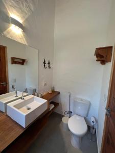 ein Badezimmer mit einem weißen Waschbecken und einem WC in der Unterkunft CasaMí in Ilhabela