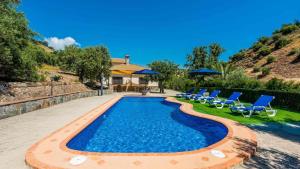 a swimming pool with chairs and a house at Casa Jose Manuel El Gastor by Ruralidays in El Gastor