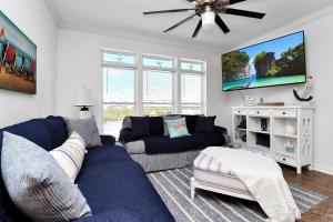 a living room with a blue couch and a tv at Bucket List by Pristine Properties Vacation Rentals in Mexico Beach